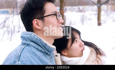 Happy young couple hugging and taking selfie in the park on snowy winter day. High quality photo Stock Photo