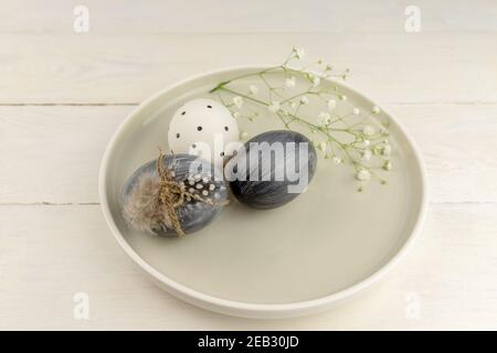 Natural dyed grey Easter eggs in a plate on rustic wooden background. High angle view point Stock Photo
