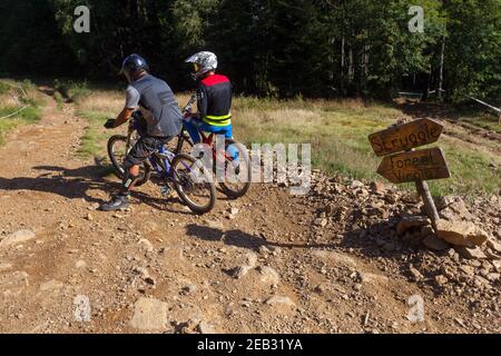 Two cyclists on a mountain bike trail, cyclists talking before going down a hill, outing Stock Photo