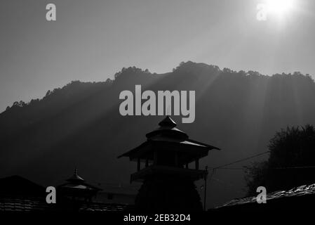 Low key shot of sun rays shining on a temple Stock Photo