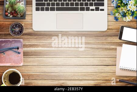Office desk table with office equipment,laptop computer, glasses, smart phone, cup of coffee and flower on wooden table background. Top view with copy Stock Photo