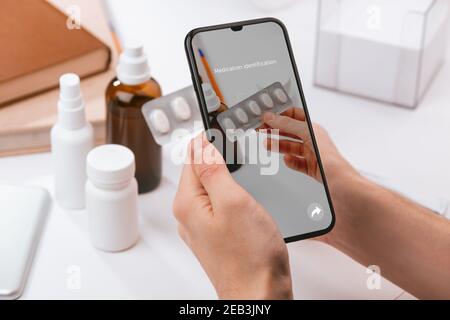Man using a phone app to recognize unknown pills Stock Photo