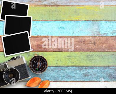 Vintage camera,compass and old blank photo frame on office desk or wooden textured background. Vintage and retro style with business travel concept. T Stock Photo