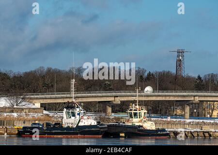 Ventspils, Latvia, February 5, 2021: two tugs in the port canal, industrial background Stock Photo