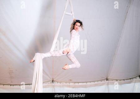 Female Aerialist acrobat performs in the air on fabric Stock Photo