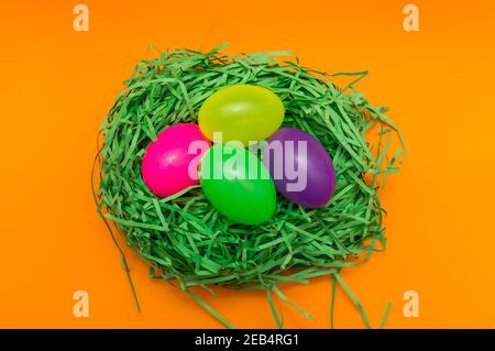 Four Colorful Easter Eggs Sitting in Green nest or Grass.Studio image. Stock Photo