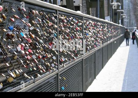 10 February 2021, Brandenburg, Schwielowsee/Ot Caputh: Padlocks with engraved names and dates hang from the grating of the railway bridge over the Caputher Gemünde or the Havel leading to the Schwielowsee. According to a custom, the love locks are attached by lovers to railings, bridges or similar fixed objects and are intended to symbolically seal the union. After attaching the lock, the key is sunk into the body of water. Photo: Soeren Stache/dpa-Zentralbild/ZB Stock Photo