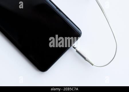 mobile smartphone audio cable jack 3.5mm and input hole on a white background Stock Photo