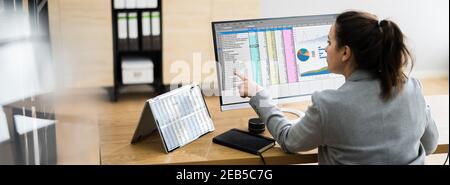 Woman Using Finance Spreadsheet Report On Laptop Screen Stock Photo