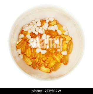 Bowl with fish oil capsules on white background, omega vitamin, yellow transparent capsules Stock Photo