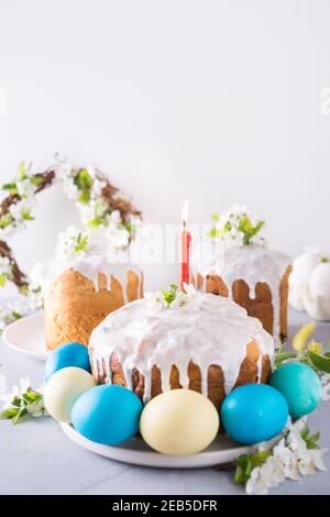 Easter cake and traditional painted eggs, blooming spring flowers. Close up. Vertical format Stock Photo