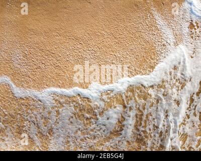 Foam from the sea wave on the sand Stock Photo
