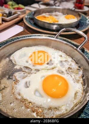 closeup fried eggs in pan for breakfast served on the table Stock Photo
