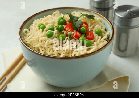 Concept of tasty eating with bowl of noodles on white textured background Stock Photo