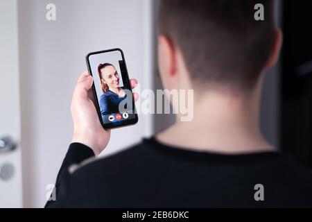 Video phone call and online virtual meeting in smartphone screen. Work conference or interview with mobile videocall on internet. Man and woman. Stock Photo
