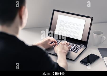 Man writing with laptop. Job applicant making his resume, cv or application. Freelance writer, journalist or teacher working in home office. Stock Photo