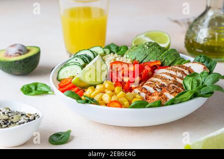 Bowl with bulgur, grilled chicken, bell pepper, cucumber, corn, avocado and spinach. Buddha bowl. Healthy food concept. Selective focus. Stock Photo