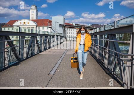 Portrait of a teenage girl at the train station with a medical face mask as measure against viral or bacterial infection Stock Photo