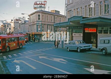 A view at the junction of Willis and Boulcott Streets, Wellington, New Zealand 1969. The trolleybuses see here were big part of the municipal transport system. These electric vehicles operated in Wellington from 1924 until 1932 and again from 1949 until 2017. It was the last trolleybus system operating in the country. The Hotel St George (right) was once one of Wellington’s top hotels. It is an Art Deco building occupying an historic corner site. It was briefly the country's largest hotel. Wellington is the capital city of New Zealand & is located at the south-western tip of the North Island. Stock Photo