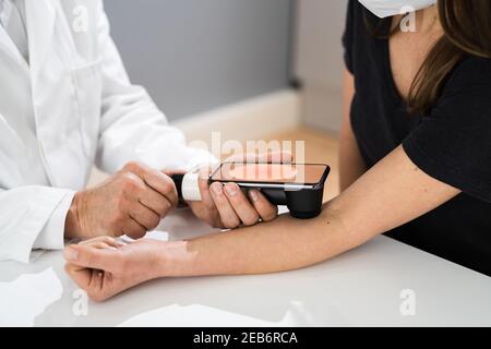 Doctor Examining Pigmented Skin Of Patient Woman Stock Photo