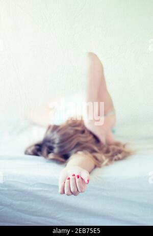 Young woman laying in bed Stock Photo