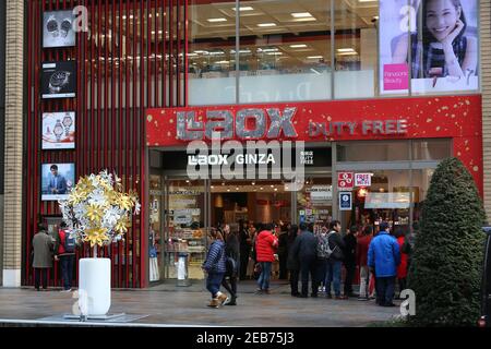 TOKYO, JAPAN - DECEMBER 1, 2016: People walk by Laox Duty Free store at Ginza district of Tokyo, Japan. Ginza is a legendary shopping area in Chuo War Stock Photo