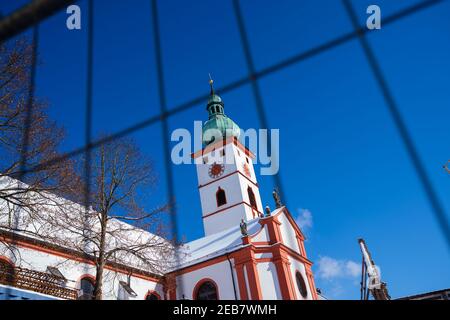 Tirschenreuth, Germany. 12th Feb, 2021. The steeple of the city's parish church of the Assumption of the Virgin Mary can be seen through a construction fence. According to the Bavarian state government, the more contagious coronavirus variant from Britain has already gained the upper hand in some eastern Bavarian regions among commuters from the Czech Republic. The proportion of the mutated variant in positive corona tests is around 70 percent in Tirschenreuth, Bavarian Prime Minister Söder (CSU) said on 'Markus Lanz'. Credit: Nicolas Armer/dpa/Alamy Live News Stock Photo