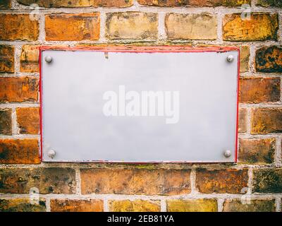 Closeup shot of a white empty board on a brick wall Stock Photo