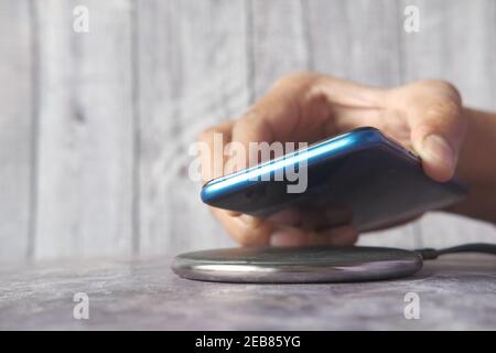 charging Smartphone using Wireless Charging Pad, top view  Stock Photo