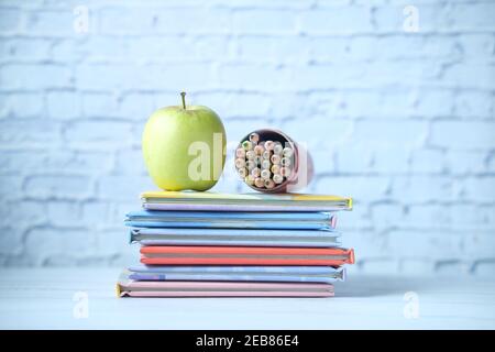 colorful books , apple and color pencil on table  Stock Photo