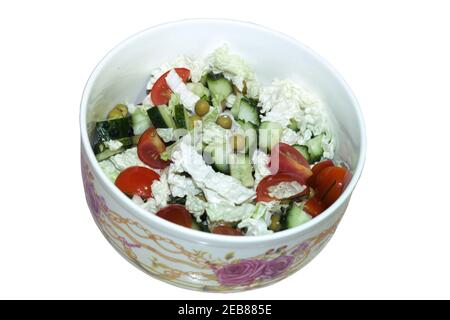 vegetable salad with fresh chopped cherry tomatoes, cucumbers, canned green peas, with peking cabbage leaves, mixed without dressing in porcelain bowl Stock Photo