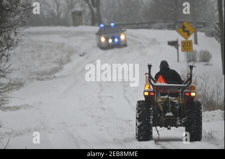 UNITED STATES - 01-31-2: A tractor driven by Jeff Puffenberger heads down to pull a car out of the ditch along Yellow Schoolhouse Road in the 'S' curv Stock Photo