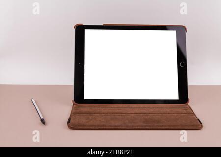 a tablet with white screen on the office table and a stylus pen near Stock Photo