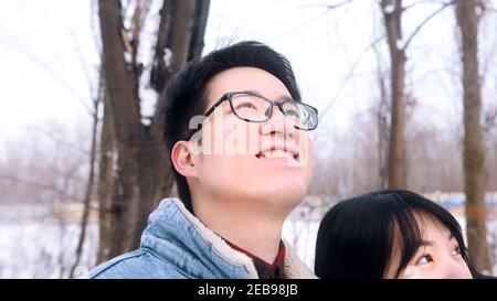 Happy young couple hugging and taking selfie in the park on snowy winter day. High quality photo Stock Photo