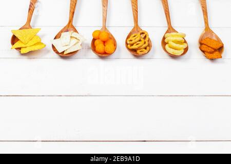 Mix of snacks : pretzels , crackers , chips and nachos on the table Stock Photo