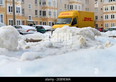 Leipzig, Germany. 10th Feb, 2021. A Deutsche Post (DHL) delivery vehicle appears to disappear behind a mountain of snow in Leipzig as it delivers parcels, packages, letters and direct mail. Credit: Volkmar Heinz/dpa-Zentralbild/ZB/dpa/Alamy Live News Stock Photo