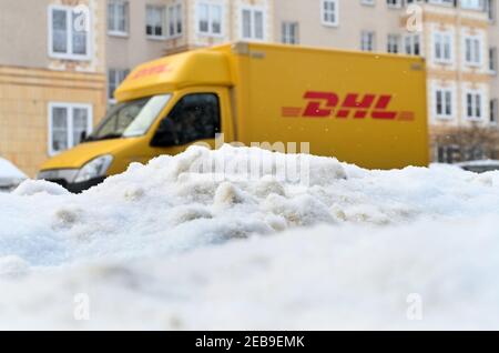 Leipzig, Germany. 10th Feb, 2021. A Deutsche Post (DHL) delivery vehicle appears to disappear behind a mountain of snow in Leipzig as it delivers parcels, packages, letters and direct mail. Credit: Volkmar Heinz/dpa-Zentralbild/ZB/dpa/Alamy Live News Stock Photo