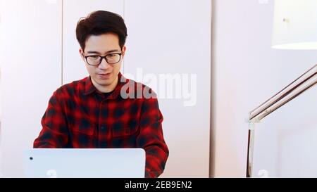 Portrait of young asian man student using laptop to study at home. Distance learning concept. High quality photo Stock Photo