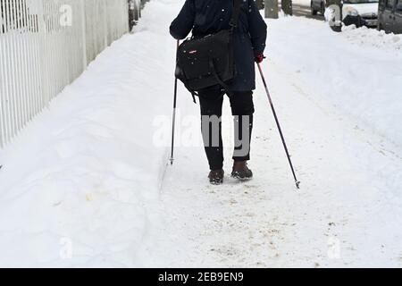 Leipzig, Germany. 10th Feb, 2021. With ski poles, an elderly woman makes her way along a footpath in Leipzig. Cleared and gritted, it's easier to make progress. Credit: Volkmar Heinz/dpa-Zentralbild/ZB/dpa/Alamy Live News Stock Photo