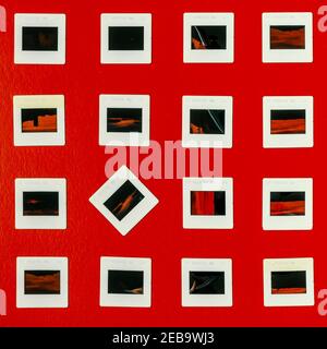A square made up of four rows of old photographic slides on a red background Stock Photo
