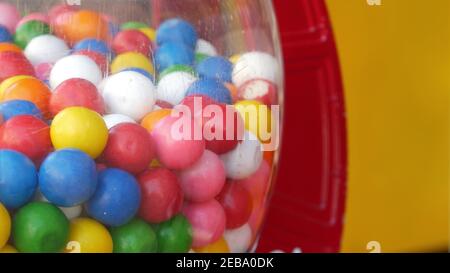 Colorful gumballs in classic vending machine, USA. Multi colored buble gums, coin operated retro dispenser. Chewing gum candies as symbol of childhood