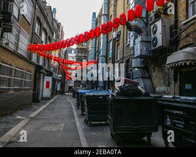 London UK 12 February 2021 A very quiet Gerrad Street in London Chinatown, with pandemic looming no celebrations were allowed this year ,people queue outside restaurants and took selfies in front of the Chinese Gates, even Dansey Place  were the bins are stored had some decorations .Paul Quezada-Neiman/Alamy Live News Stock Photo