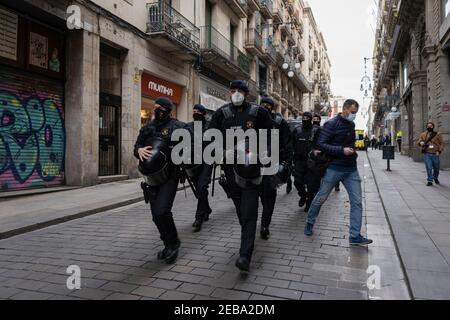 Spain. 12th Feb, 2021. Anti-riot agents of the Mossos de Esquadra persecute the anti-fascists around Sant Jaume Square in Barcelona, Spain, during the demonstration called by Jusapol on February 12, 2021. (Photo by Pau de la Calle/Sipa USA) Credit: Sipa USA/Alamy Live News Stock Photo