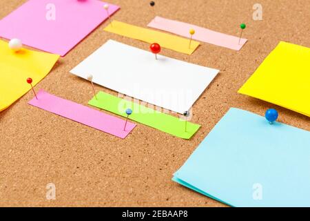 Cork board with several colorful blank notes with pins Stock Photo