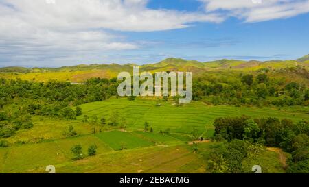 Hills and mountains covered with green grass against a background of blue sky and clouds. Bohol, Philippines. Summer landscape. Stock Photo