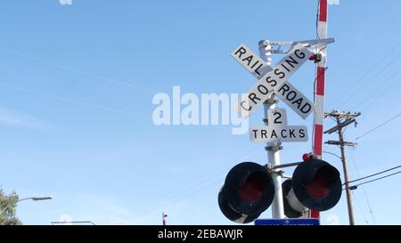Level crossing warning signal in USA. Crossbuck notice and red traffic light on rail road intersection in California. Railway transportation safety sy Stock Photo