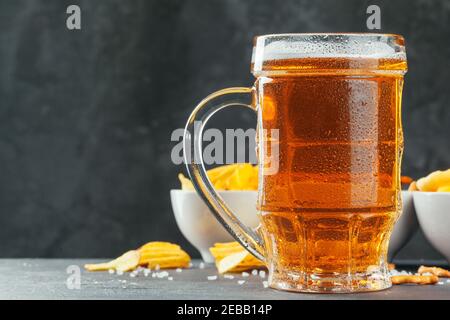 Lager beer and snacks on stone table. Cracker, chips side view Stock Photo
