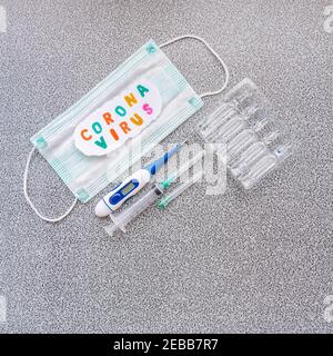 Word Coronavirus, medical face mask and medical equipment on spotty background. Pandemic coronavirus infection prevention concept. Novel coronavirus 2 Stock Photo