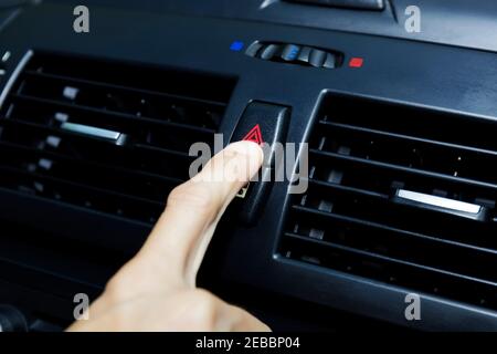 Close up hand press the emergency light in the car, Fingers press button.for open the contract emergency light in car. Emergency button press for open Stock Photo