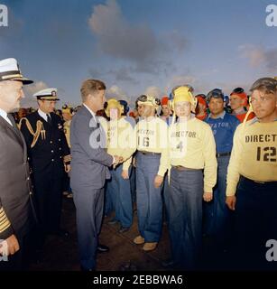 Trip to Western States: Visit to the Pacific Fleet, President Kennedy aboard the USS Kitty Hawk, 5:00PM. President John F. Kennedy (left) shakes hands with an unidentified flight deck crew member aboard the aircraft carrier USS Kitty Hawk (CVA-63), at sea off the coast of San Diego, California; Commander-in-Chief of the Pacific Fleet (CINCPACFLT), Admiral John H. Sides, and Naval Aide to the President, Captain Tazewell T. Shepard, Jr., stand at far left. Stock Photo